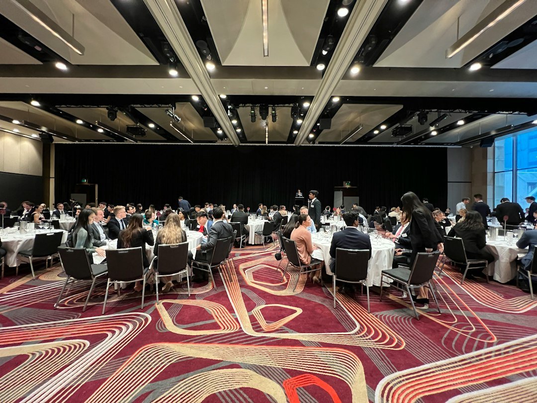 a-group-of-people-sitting-at-tables-8bzns8ruaug